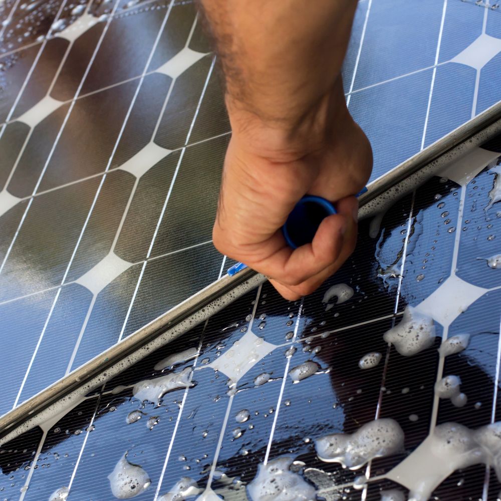 Specialist cleaning tool removing dirt and debris from residential solar panels to improve solar panel efficiency